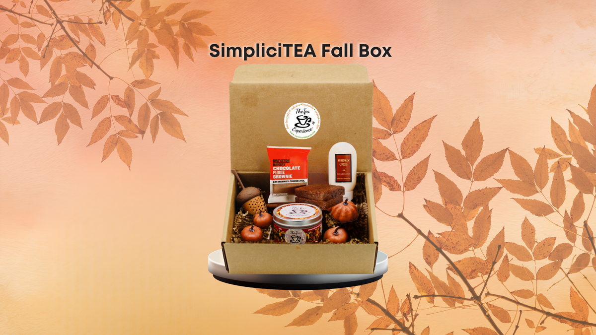 SimpliciTEA Fall Box gift set displayed in an open kraft paper box, featuring tea, snacks, and small autumn-themed items, set against a warm orange background with leafy branches and the text 'SimpliciTEA Fall Box'.